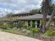 Two story tan home with stone accents, mature landscaping, and a shingled roof in a well-maintained neighborhood at 1606 The Oaks Dr, Maitland, FL 32751