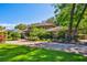 Two story tan home with stone accents and mature landscaping viewed from the lush front lawn at 1606 The Oaks Dr, Maitland, FL 32751