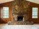 Spacious living room featuring a stone fireplace and wood paneled walls at 1606 The Oaks Dr, Maitland, FL 32751