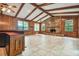 Spacious living room with wood paneling, tile flooring, fireplace, and beamed ceiling at 1606 The Oaks Dr, Maitland, FL 32751