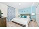 Bright bedroom showcases a cozy bed, turquoise accent wall, and charming decor for a relaxing retreat at 2004 Summer Dr, Davenport, FL 33897