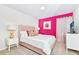 Charming bedroom features a soft pink accent wall, comfortable bed, and inviting atmosphere for relaxation at 2004 Summer Dr, Davenport, FL 33897