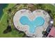 Aerial view of the community pool showcasing a unique shape and ample space for sunbathing at 202 Stargrass Dr, Auburndale, FL 33823