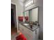 Bathroom featuring a granite countertop, white cabinetry, large mirror and modern vanity lighting at 202 Stargrass Dr, Auburndale, FL 33823