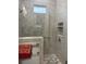 Modern tiled shower features glass door, built-in niche, chrome fixtures, and patterned floor tiles at 202 Stargrass Dr, Auburndale, FL 33823