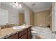 Bathroom with dark wood vanity, bathtub with tile surround, and decorative plant accent at 248 Carina Cir, Sanford, FL 32773