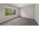 Bright bedroom with carpet, ceiling fan, and a large window providing natural light and views of lush greenery at 248 Carina Cir, Sanford, FL 32773