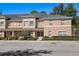 Exterior view of tan and grey townhouse with a parking lot in front at 248 Carina Cir, Sanford, FL 32773