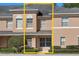 Exterior view of tan and grey townhouse surrounded by mature landscaping at 248 Carina Cir, Sanford, FL 32773