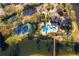 Overhead aerial view of a community pool and clubhouse with landscaping, a spa, tennis courts, and surrounding pond at 2582 Greenwillow Dr, Orlando, FL 32825