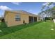 Manicured backyard featuring lush grass, a privacy fence, and a screened-in lanai with a hose for yard maintenance at 2582 Greenwillow Dr, Orlando, FL 32825