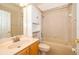 Cozy bathroom with wood cabinets, a white tile shower/tub, and white toilet at 2582 Greenwillow Dr, Orlando, FL 32825