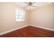 This bedroom features hardwood floors, a ceiling fan, and a window for natural light at 2582 Greenwillow Dr, Orlando, FL 32825