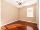 This bedroom features hardwood floors, a ceiling fan, and a window for natural light at 2582 Greenwillow Dr, Orlando, FL 32825