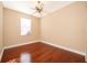 This bedroom features hardwood floors, a ceiling fan, and a window for natural light at 2582 Greenwillow Dr, Orlando, FL 32825