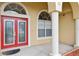 Welcoming front entry with red double doors, white columns, and arched transom windows at 2582 Greenwillow Dr, Orlando, FL 32825