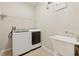 Laundry room featuring a white washer and dryer, sink, and shelving at 2582 Greenwillow Dr, Orlando, FL 32825