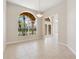 Bright, open living room with tile floors, archways, and transom window with a view of palm trees at 2582 Greenwillow Dr, Orlando, FL 32825