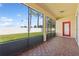 Screened in patio with view of backyard, pavers, and red door at 2582 Greenwillow Dr, Orlando, FL 32825