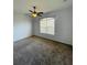 A carpeted bedroom with a ceiling fan, and large window provides natural light at 2634 Rutledge Ct, Winter Haven, FL 33884