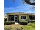 Back exterior view of the home with a screened patio, lawn, and manicured bushes at 2634 Rutledge Ct, Winter Haven, FL 33884