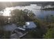 Aerial shot of home, lake and wooded surroundings, showcasing an RV and ample parking at 2674 Kingsdale Dr, Deltona, FL 32738