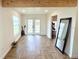 Bright living room with light-colored herringbone floors, beamed ceiling, and double glass doors to outdoors at 2674 Kingsdale Dr, Deltona, FL 32738