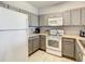 Bright kitchen featuring white appliances, grey cabinets, and tile floors at 3175 Feltrim Pl # 304, Kissimmee, FL 34747