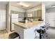 Kitchen with bar seating, white appliances and grey cabinets at 3175 Feltrim Pl # 304, Kissimmee, FL 34747