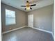 This bedroom features a ceiling fan, window, and gray tile flooring at 345 Gardenia Ct, Kissimmee, FL 34759