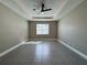 Bedroom features neutral walls, tiled floor, and a ceiling fan with lighting at 345 Gardenia Ct, Kissimmee, FL 34759