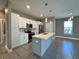 Modern kitchen features white cabinets, stainless steel appliances, and a large island with pendant lighting at 345 Gardenia Ct, Kissimmee, FL 34759