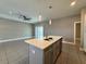 A kitchen island featuring bar seating, a stainless steel sink, and pendant lighting at 345 Gardenia Ct, Kissimmee, FL 34759