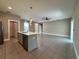 A view of the kitchen island, living room, and a stainless steel refrigerator at 345 Gardenia Ct, Kissimmee, FL 34759