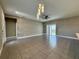 Bright, open-plan living room with neutral walls, tiled floor, modern ceiling fan, and sliding glass doors at 345 Gardenia Ct, Kissimmee, FL 34759