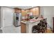 Kitchen featuring stainless steel appliances, light wood cabinets, and bar stool seating at 3658 Caruso Pl, Oviedo, FL 32765