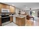 Open concept kitchen featuring stainless steel appliances and natural wood cabinets at 3658 Caruso Pl, Oviedo, FL 32765