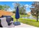 Patio area with outdoor seating, a grill, and a serene view of the pond with fountain at 3658 Caruso Pl, Oviedo, FL 32765