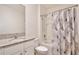 Bright bathroom featuring granite countertop vanity and tub-shower combo with a leafy design shower curtain at 411 Lazio Cir, Debary, FL 32713