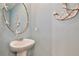 Nautical themed half-bathroom with decorative mirror and pedestal sink at 411 Lazio Cir, Debary, FL 32713