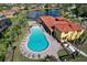 Aerial view of a lagoon shaped community pool with ample lounge seating by a lake at 411 Lazio Cir, Debary, FL 32713