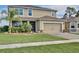 Beautiful two-story home showcasing lush landscaping and a convenient two-car garage at 411 Lazio Cir, Debary, FL 32713