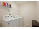 Practical laundry room with a white washer and dryer, with a shelf for storage of laundry products at 411 Lazio Cir, Debary, FL 32713