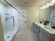 Bathroom with dual sinks, quartz countertop, and a glass-enclosed shower at 5017 Blue Hammock Ct, Kissimmee, FL 34746