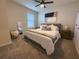 Bedroom with ceiling fan, large bed, wood nightstand, neutral colored walls, and full-length mirror at 5017 Blue Hammock Ct, Kissimmee, FL 34746