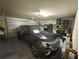 A well-lit garage with epoxy floors featuring an SUV and ample storage and organization at 5017 Blue Hammock Ct, Kissimmee, FL 34746