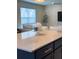 Kitchen island boasts a white vase and blue glass candleholder on a white countertop and navy blue cabinetry at 5017 Blue Hammock Ct, Kissimmee, FL 34746