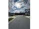 Neighborhood street view lined with sidewalks and young trees on a sunny day at 5017 Blue Hammock Ct, Kissimmee, FL 34746