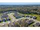 Panoramic aerial view of a newly developed neighborhood with landscaped streets and a secure perimeter fence at 5315 Meadow Song Dr, Okahumpka, FL 34762