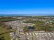 Expansive aerial view of a well-maintained community with lush landscaping and a tranquil pond at 5315 Meadow Song Dr, Okahumpka, FL 34762